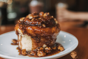 Image of homemade bakery, brown caramel bun, putting on white plate.