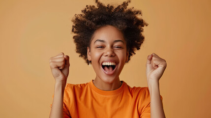 Portrait of an excited young black young woman isolated on beige background 