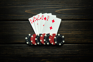A successful combination of flush playing cards and winning chips on a vintage table. Winning in...