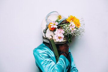 fine art concept with man wearing a space helmet and flowers composition
