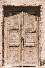 An ancient wooden door with patterns and ornaments in the ancient city of Khiva in Uzbekistan, wood carving