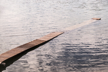 Wooden boardwalk leading into lake waters