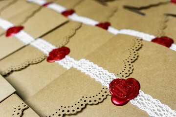 Closeup shot of decorative brown vintage envelopes with lace and a red stamp