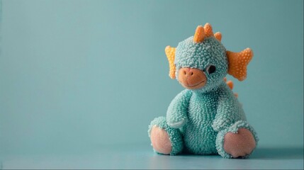 a small stuffed animal sitting on top of a table next to a blue background