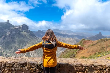 Photo sur Aluminium les îles Canaries A tourist woman looking at Roque Nublo from a viewpoint with her arms open. Gran Canaria, Spain