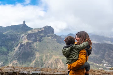 Papier Peint photo autocollant les îles Canaries A mother with her son looking at Roque Nublo from a viewpoint. Gran Canaria, Spain