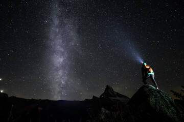 Starry night sky over Matterhorn with lone observer