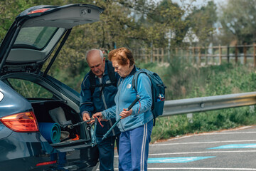 senior couple equipping themselves in the car for hiking - 781170925