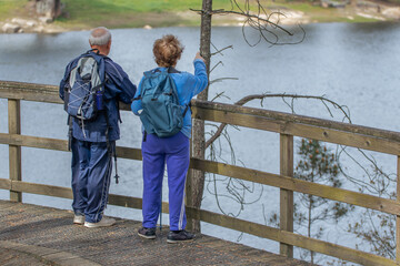 senior couple hiking outdoors in nature - 781171310