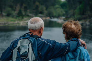 senior couple hiking outdoors in nature - 781171516