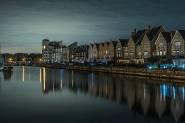 Fototapeta premium Night view of houses among the canal with light reflected in the water