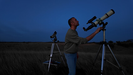 Amateur astronomer looking at the evening skies, observing planets, stars, Moon and other celestial...