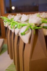 Vertical shot of brown gift boxes decorated with small bags for a wedding event