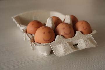 Closeup shot of eggs with painted emotions in an egg carton