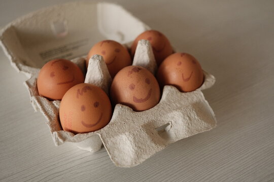 Closeup shot of eggs with painted emotions in an egg carton