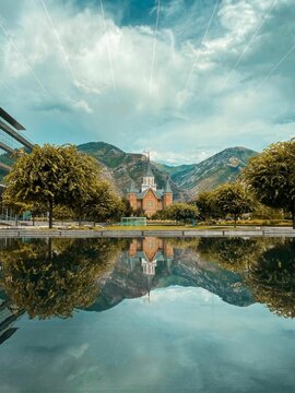 Vertical shot of the Provo City Center Temple with mountains reflected in the water