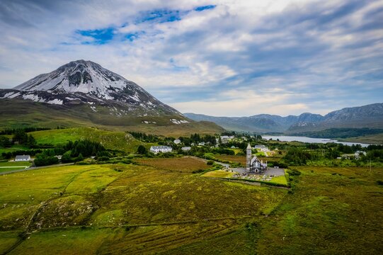 Aerial shot of a small countryside church with the Errigal mountain in the background in Ireland