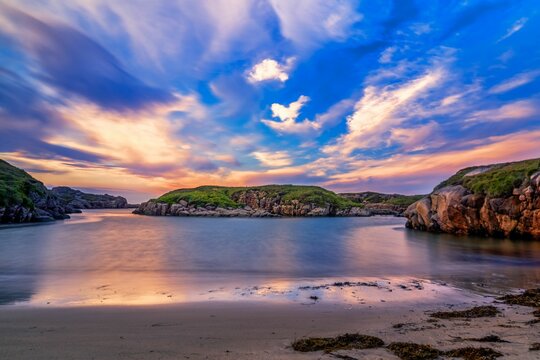 Long exposure view of water waves and coastal cliffs at sunset in Donegal