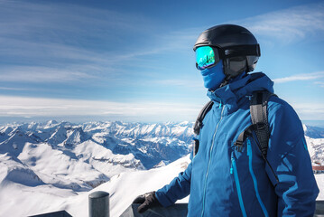 Person in winter sports attire, Murren ski resort, Switzerland. Blue ski jacket, helmet, goggles. Stunning mountain views. Ideal for skiing and snowboarding.