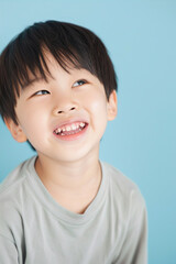 Little boy smiling on blue background
