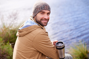 Camping, smile and portrait of man with coffee by lake in nature for adventure, travel and outdoor vacation. Holiday, back view and male person with hot beverage for relax, peace and happiness
