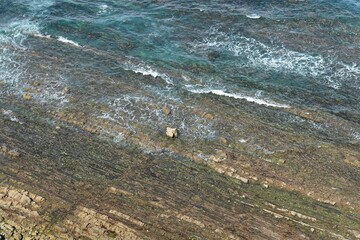 Aerial view of rocks in the sea on a sunny day