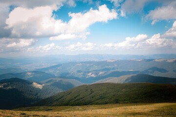 Beautiful view of Mount Hoverla in a grass valley with floating clouds above in Ukraine