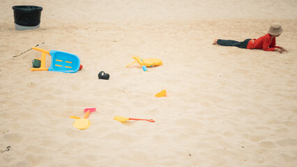 Kid and colorful plastic toys on the sand. Shenzhen, China