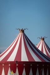 Aerial view of red and white circus tents with crowns © Wirestock