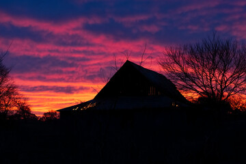 Tranquil barn silhouette standing out beneath a stunning sunrise