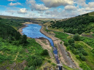 Fototapeta na wymiar Aerial shot of a reservoir of blue water around green plants in Yorkshire, UK