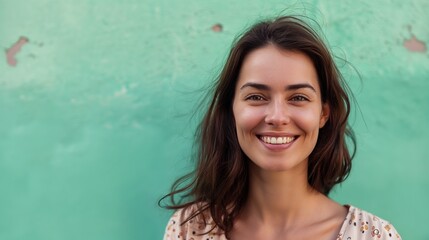 Portrait of a woman smiling on a aquamarine colored background, copy space.