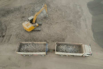 excavator scooping rocks, stone construction - 781192751