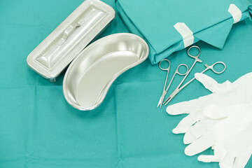 Surgical set and medical equipment on green surgical tray inside operating room.Sterile surgical instrument tool equipment for surgery.Infection control. - obrazy, fototapety, plakaty