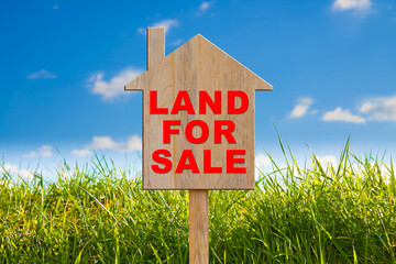 Vacant Land for Sale with wooden advertising sign in a rural scene and small home icon - Real Estate concept