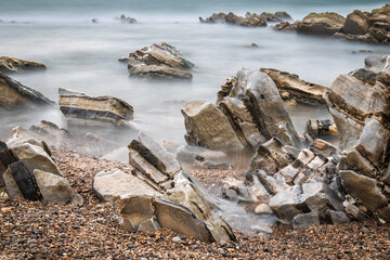 atlantic coastline in bidart, rocks and water in long exposure