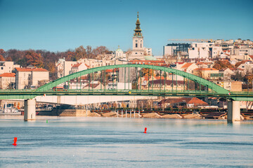 Serene waters of the Sava river frame Belgrade's skyline, blending ancient architecture with modern citylife in a captivating urban scene. - obrazy, fototapety, plakaty