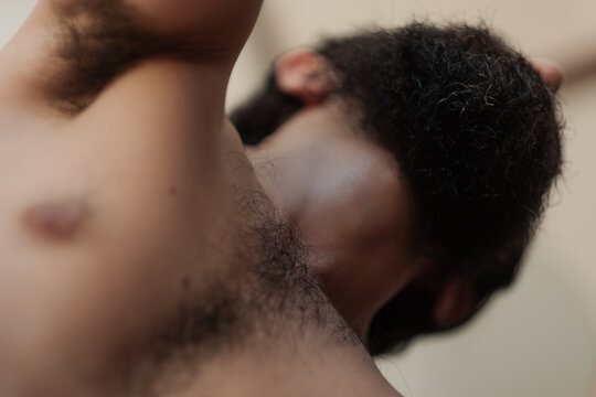 Self portrait of a man's upper body, showing his chest hair, underarm hair. The selective focus highlights his body hair but leaves his thick beard out of focus, adding a close and intimate feeling.