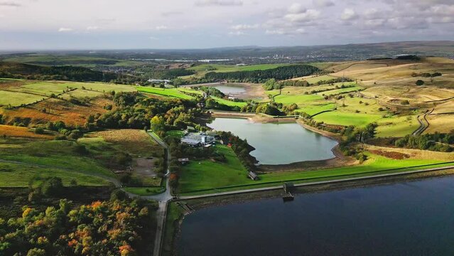 Drone footage over lake by Saddleworth moor Reservoirs with moorland in England with cloudy sky