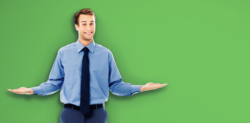 Comparison concept - confident businessman showing, hold or give something on both flat hands for similar choice, isolated green chroma key background. Empty free ad place, text area.