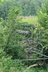 Close Up of Old Overgrown Derelict Stone Building with Supporting Scaffolding seen in Woodland 
