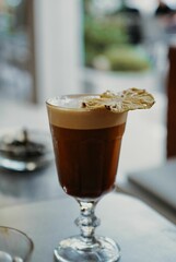 Vertical shot of a cup of coffee in glass on the white table