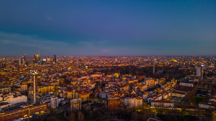 Fototapeta na wymiar Urban skyline of Italian metropolis at sunset. Italy, Lombardy, Milan. Copy space.