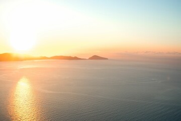 Obraz premium Aerial view of lake surrounded by hills during sunrise