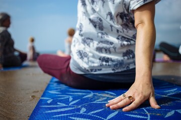 Set of people holding yoga poses on the shore of the beach