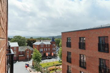 View of red brick buildings and the street under a cloudy sky.
