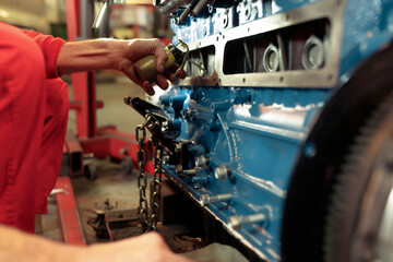Closeup shot of a mechanic mounting the car engine