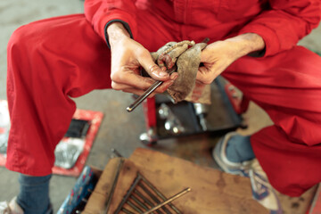 Closeup shot of a mechanic cleaning his tools to mount the car engine
