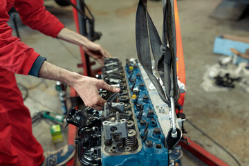 Fototapeta premium Young Caucasian mechanic mounting the car engine
