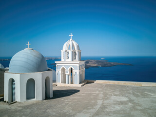 Santorini con le tradizionali cupole sul mar Egeo, panorama per cataloghi viaggi e copertine turistiche - obrazy, fototapety, plakaty